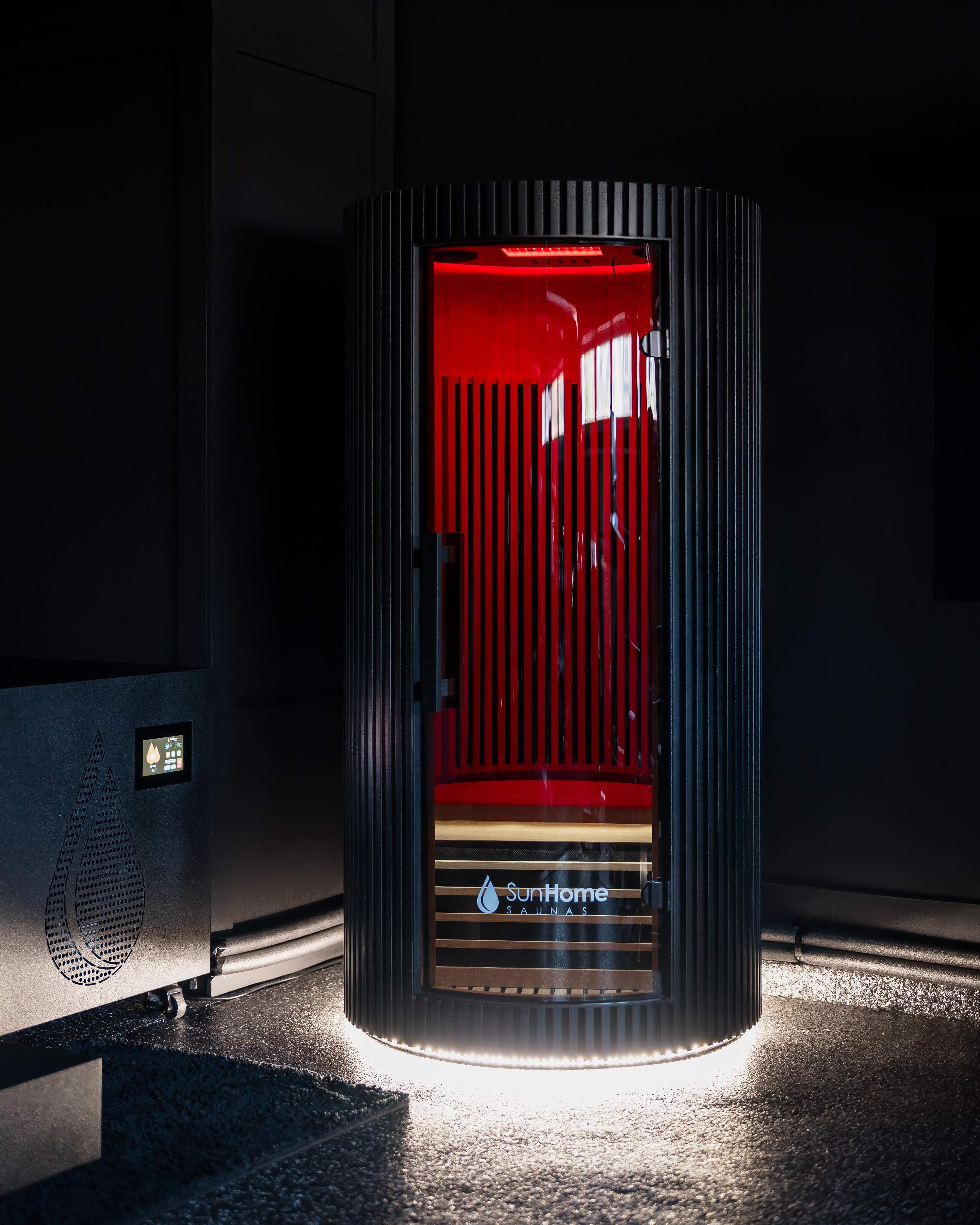 Black Sun Home Pod 1-person red light infrared sauna, door closed with a warm red interior glow
