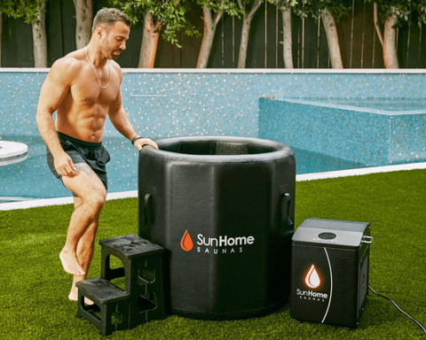 Man stepping up to enter the Sun Home Cold Plunge - Vertical tub with chiller and step stool on backyard grass